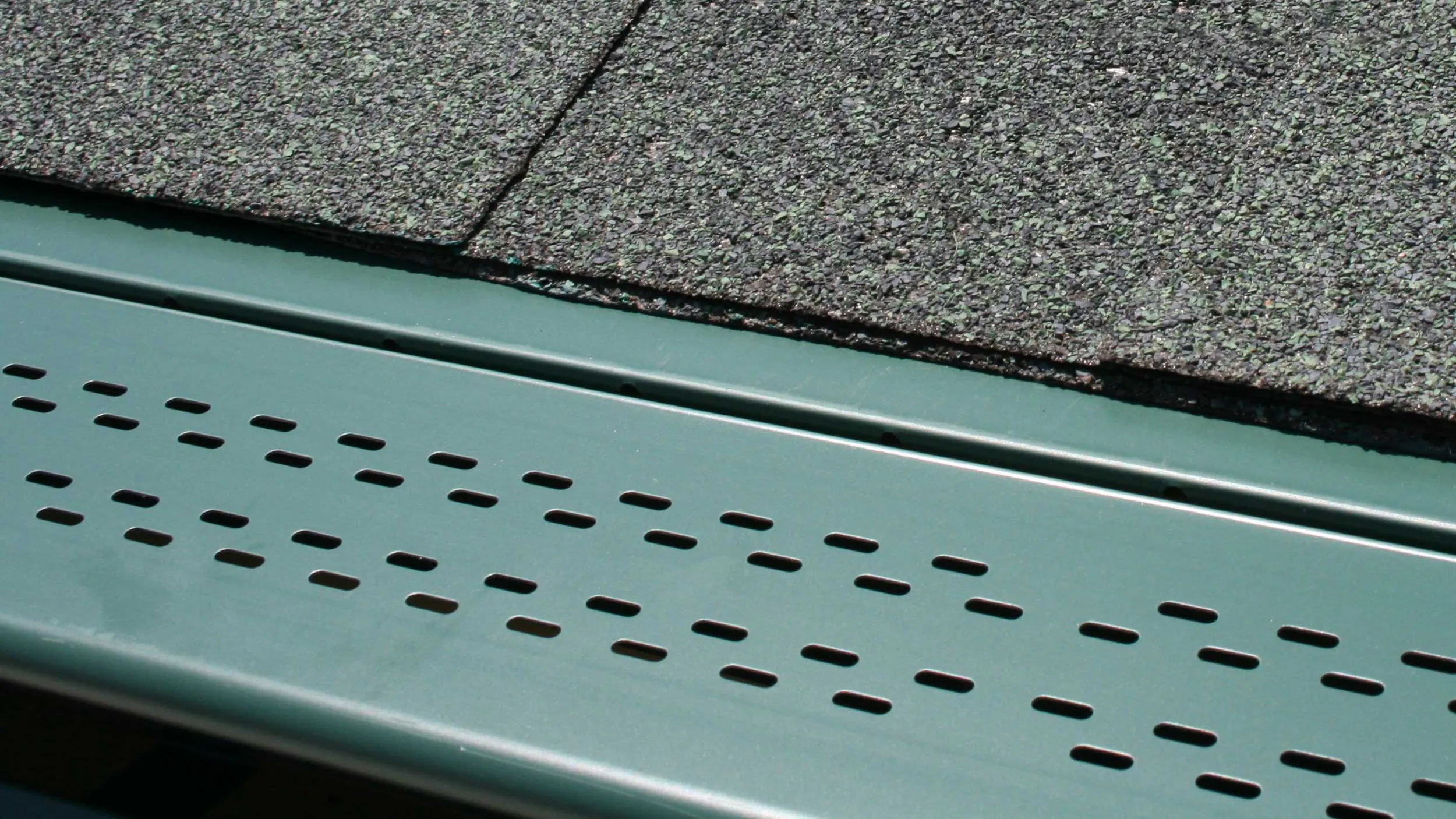Close-up of an actual LeaFree panel in Green: the low-profile hood that tucks under the shingle line.